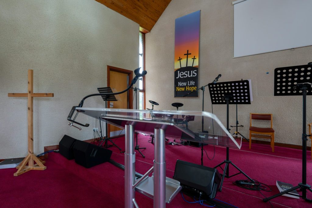 a church with a cross, microphones, and other musical equipment