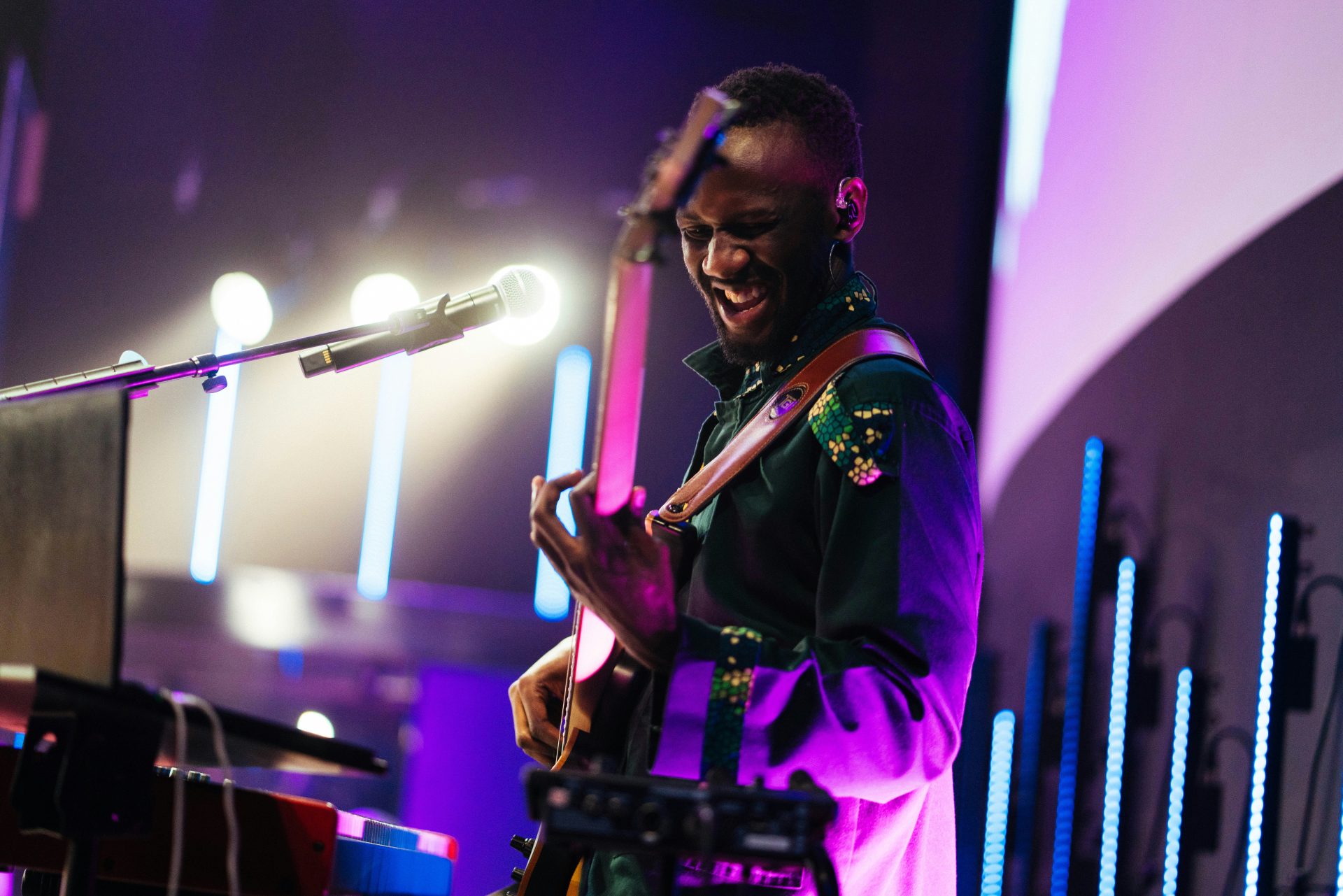 A musician plays guitar on stage.